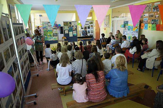 uczniowie wraz z opiekunami słuchają koncertu w sali szkolnej (fot. Michalina Kapelan) grafika